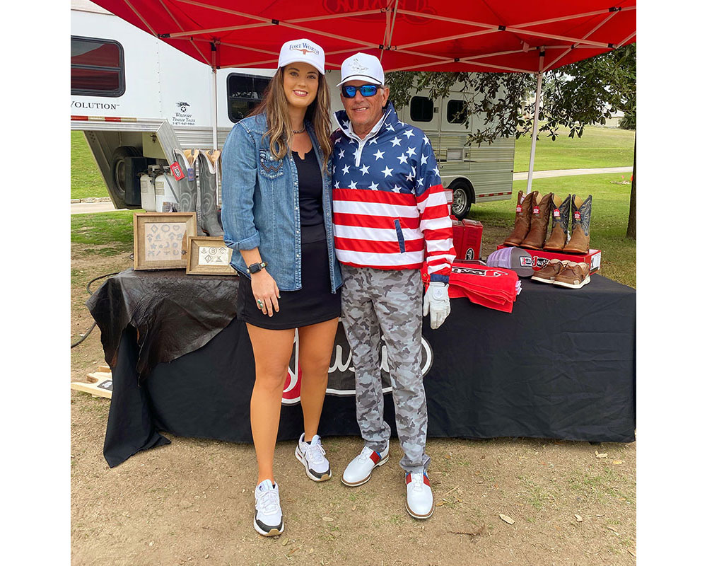 A woman, Shelbi Tidwell, with George Strait, in the sun at a golf tournament.